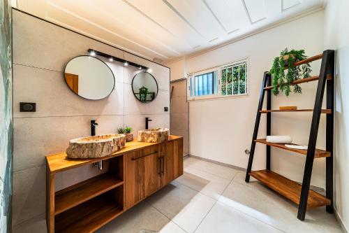 a bathroom with a wooden sink and a mirror at Villa Horizon Bleu - Vue Mer & Piscine Chauffée in Le Tampon