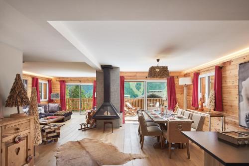 un salon avec une table et une cheminée dans l'établissement Luxueux chalet avec terrasse Auron, à Saint-Étienne-de-Tinée