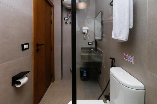 a small bathroom with a toilet and a sink at Rixoss Tower Pyramids View in Cairo