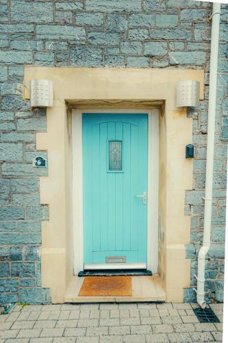 a blue door in a stone building with a brick wall at Drakes Nest Plymouth City Centre Location and FREE PARKING in Plymouth