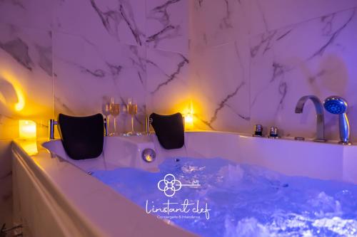 bañera en una habitación con iluminación púrpura en Love au Mans - Sauna et Jacuzzi inclus, en Le Mans