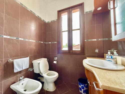 a bathroom with a toilet and a sink at VITA'S BEACH House in Diani Beach