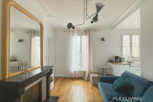 - un salon avec un miroir et un canapé bleu dans l'établissement Flexliving - T2 - Eugène Gibez, à Paris