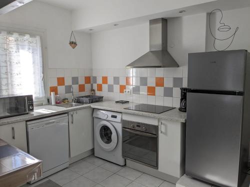 Il comprend une cuisine équipée d'un réfrigérateur et d'un lave-linge/sèche-linge. dans l'établissement Appartement cœur de ville, à Bessan