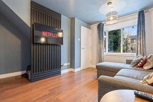 a living room with a television and a couch at Emma's Central House & Parking in Nottingham