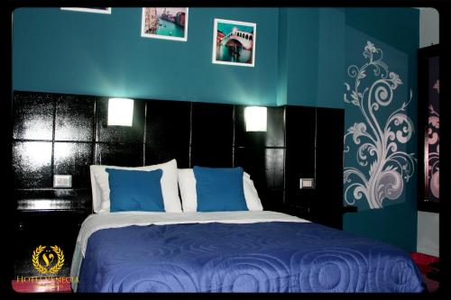 a bedroom with a bed with blue and black walls at Hotel Venecia in Huánuco