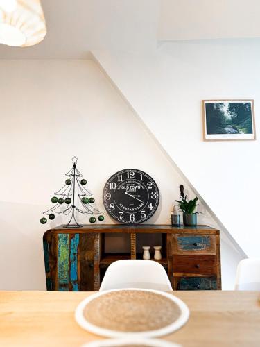 une salle à manger avec une horloge et un arbre de Noël dans l'établissement Appartment Le Saint Martin, à Saint-Dié-des-Vosges