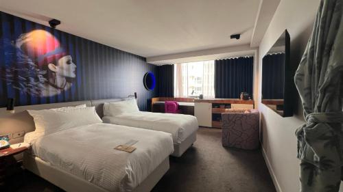 a hotel room with two beds and a desk at Hotel Indigo Sydney Potts Point by IHG in Sydney
