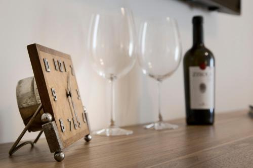 a bottle of wine and two wine glasses on a table at B&B Vicere Speciale in Noto