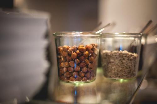 two glass jars filled with nuts and seeds on a table at Hotel Alexander in Wiesbaden