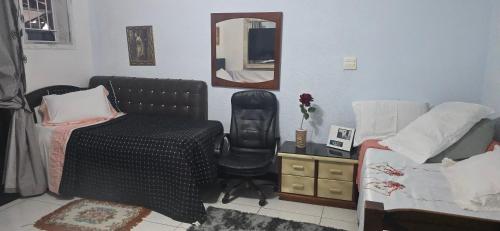 a bedroom with a bed and a chair and a mirror at Espaço TOP São Paulo - Brazil in Sao Paulo
