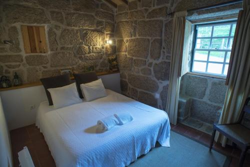 a bedroom with a bed with a towel on it at Quinta do Caritel in Vouzela