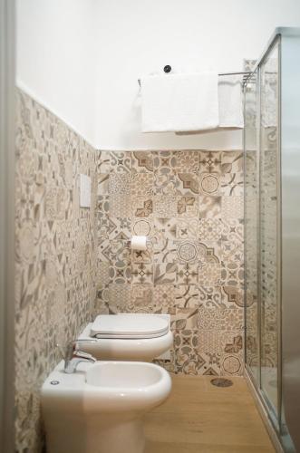 a bathroom with a toilet and a glass shower at Binario 14 Piazza Garibaldi in Naples