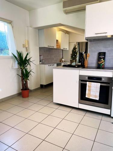 une cuisine avec des armoires blanches et un four noir dans l'établissement Appartement Lumières, à Pontault-Combault
