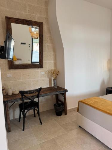 a bedroom with a desk with a mirror and a bed at Dimora Caraspi in Mola di Bari