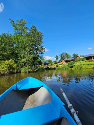 a blue boat in the water on a river at Apardo Chaty Březka - Trojka in Březka