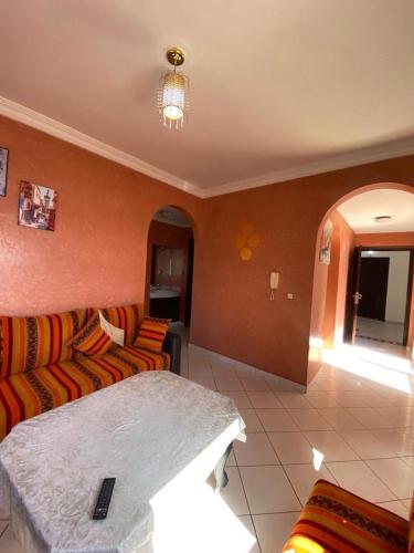a living room with a couch and a table at Sunrise sea view apartment A17 in Tamraght Oufella
