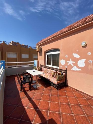 a patio with a bench and a table on a balcony at Sunrise sea view apartment A17 in Tamraght Oufella