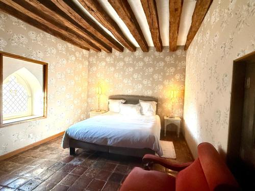 a bedroom with a bed and a chair at Demeure des Vieux Bains in Provins