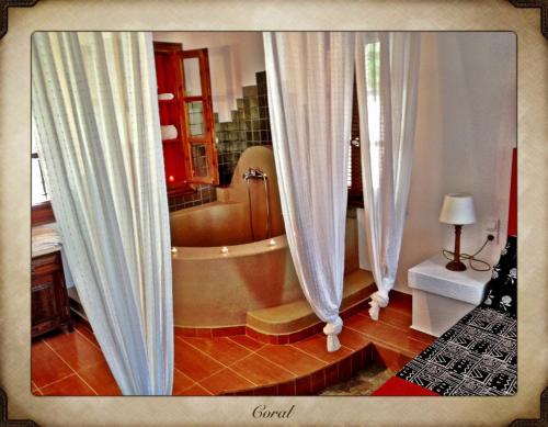 a bathroom with a tub and a shower curtain at Aperanto Galazio in Skopelos Town