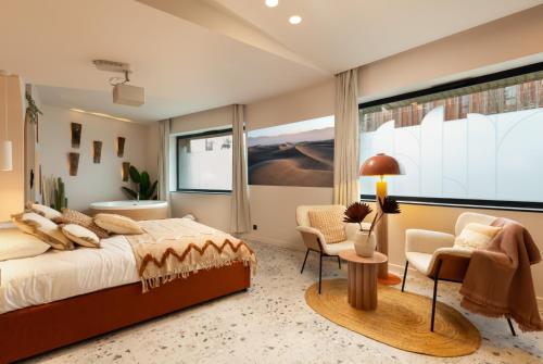 - une chambre avec un grand lit, un bureau et des chaises dans l'établissement Suite romantique Ibiza, Jacuzzi, Spa, à Strasbourg