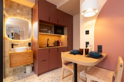 a small kitchen with a wooden table and a sink at Suite romantique Ibiza, Jacuzzi, Spa in Strasbourg