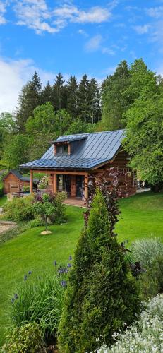 a house with a metal roof on a green yard at Apardo Chaty Březka - Trojka in Březka