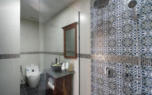 a bathroom with a shower with a toilet and a mirror at The Nest in Siem Reap