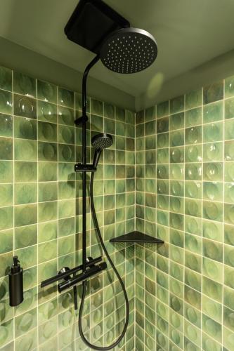 a shower in a bathroom with green tiles at Suite romantique Bali, Sauna , Spa in Strasbourg