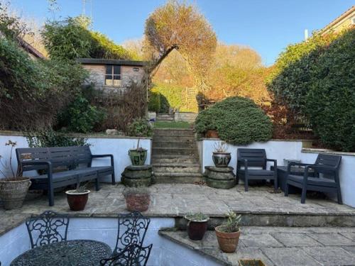 a patio with two benches and stairs with plants at Bulldog Cottage in Ampleforth
