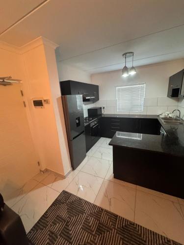 a large kitchen with black and white appliances at Trade with Armani in Richwood
