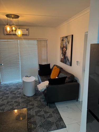 a living room with a couch and a table at Trade with Armani in Richwood
