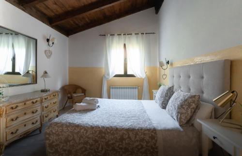 sypialnia z łóżkiem, komodą i lustrem w obiekcie El Manantial Del Fresno Casas Rurales En Hervás - Piscina - Desayunos - Barbacoa - Parking gratis w mieście Hervás