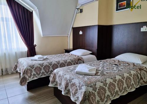 a hotel room with two beds with towels on them at Готель "Валерія" in Novoselytsya