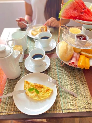 a table topped with plates of breakfast foods and coffee at Pousada Água Viva in Paraty