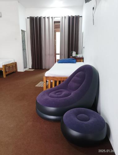 a bedroom with a bed with a purple ottoman at Kithaya Ella in Ella