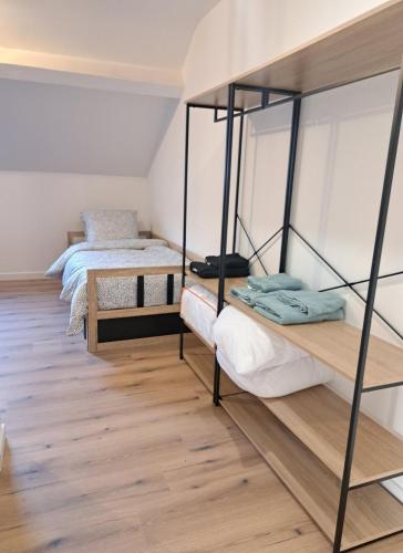 deux lits dans une chambre avec parquet dans l'établissement Gîte de groupe Ardennais 18p, à Haybes