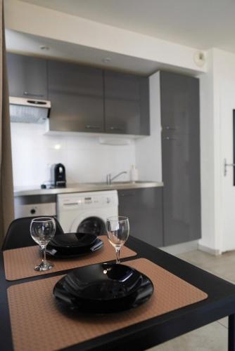 une cuisine avec une table avec deux verres et une table sidx sidx sidx dans l'établissement Studio Hypercentre, proche gare et métro, à Toulouse