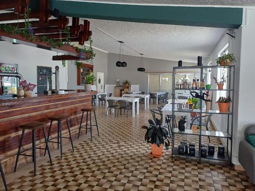 a restaurant with a bar and tables and chairs at Parque de Campismo Orbitur Valverde in Luz