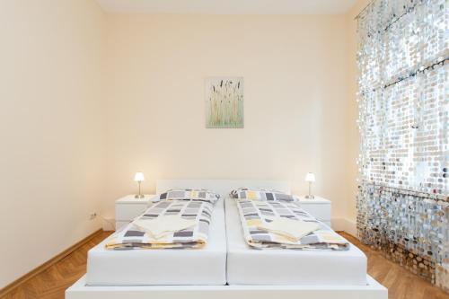 two white beds in a white room with a painting at GreatStay Apartment - Bornstedterstr. in Berlin