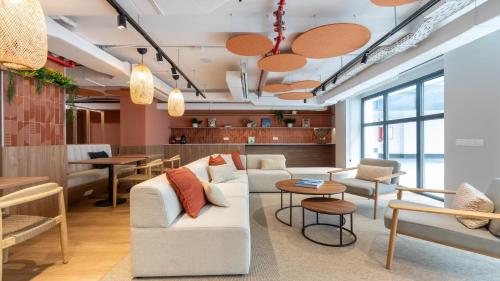 a living room with a couch and chairs and tables at Hotel Nido Príncipe Pío in Madrid