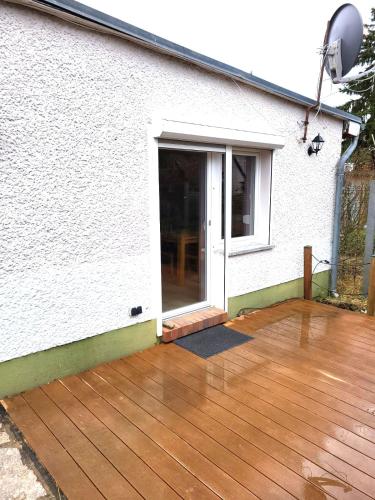 a wooden deck in front of a house at Monteur-Haus Heinrich Berlin Marzahn, Hellersdorf, Lichtenberg in Berlin