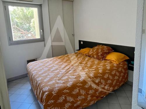 une chambre avec un lit avec une couette et une fenêtre dans l'établissement Quartier plage 1 chambre Parking Climatisation Internet, à Sète
