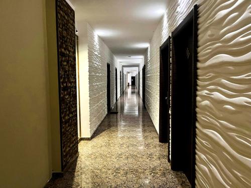 a hallway with a long corridor with white walls at Aryana Queen Beach Resort in Wadduwa