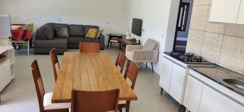 a kitchen with a wooden table and a couch at stone house in Balneário Gaivotas