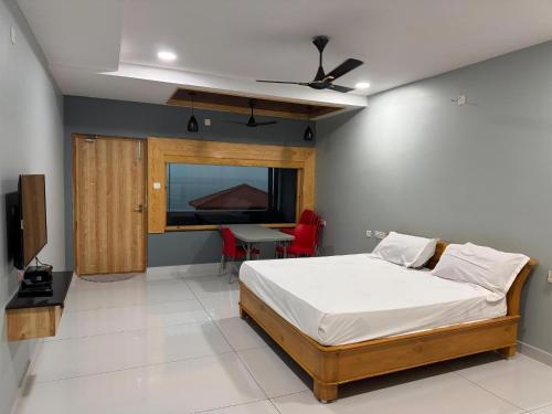 a bedroom with a bed and a table and a television at Yanam resorts in Yanam
