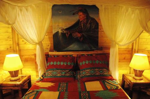a bedroom with a painting of a man on the wall at Insolite Ara Wakan / Ma cabane in Pointe-Noire