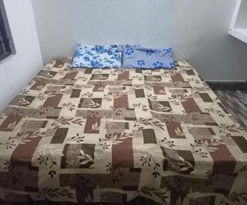 a bed with a quilt on it in a room at Mahi Home Stay in Jhūsi