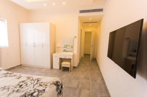 a bedroom with a bed and a desk and a tv at Accra Luxury Apartments at Lul Water in Accra
