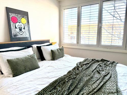 a bedroom with a large bed with a blanket on it at Modern & Central Apartment - Zurich Oerlikon in Zürich